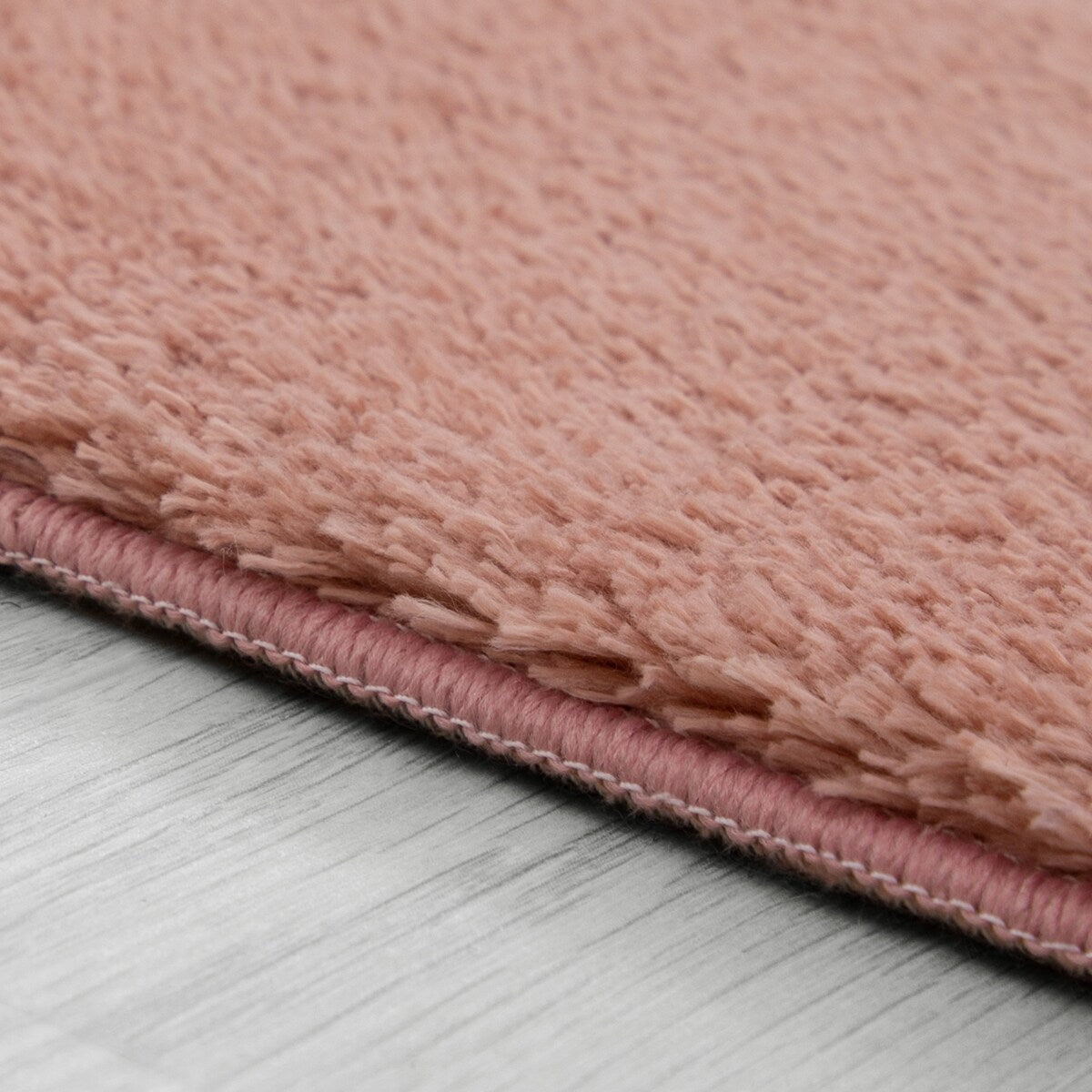 Tapis doux et lavable avec envers antidérapant, disponible en couleurs unies.